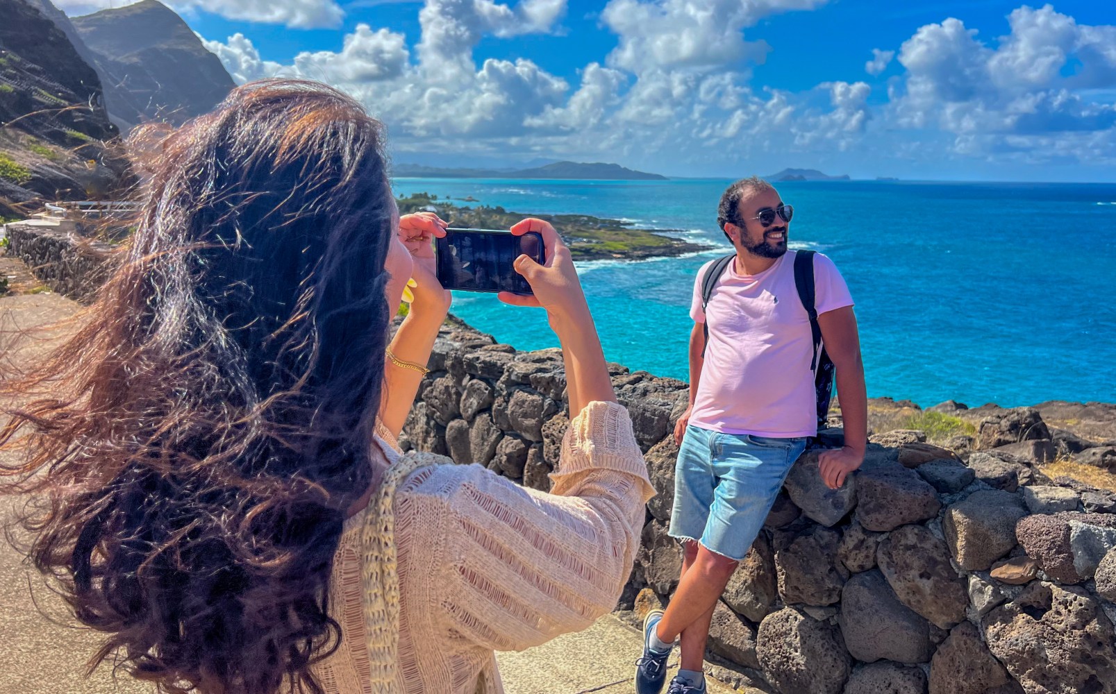 OPT Guest capturing a photo of her partner at a scenic Oahu lookout, showcasing breathtaking island views."